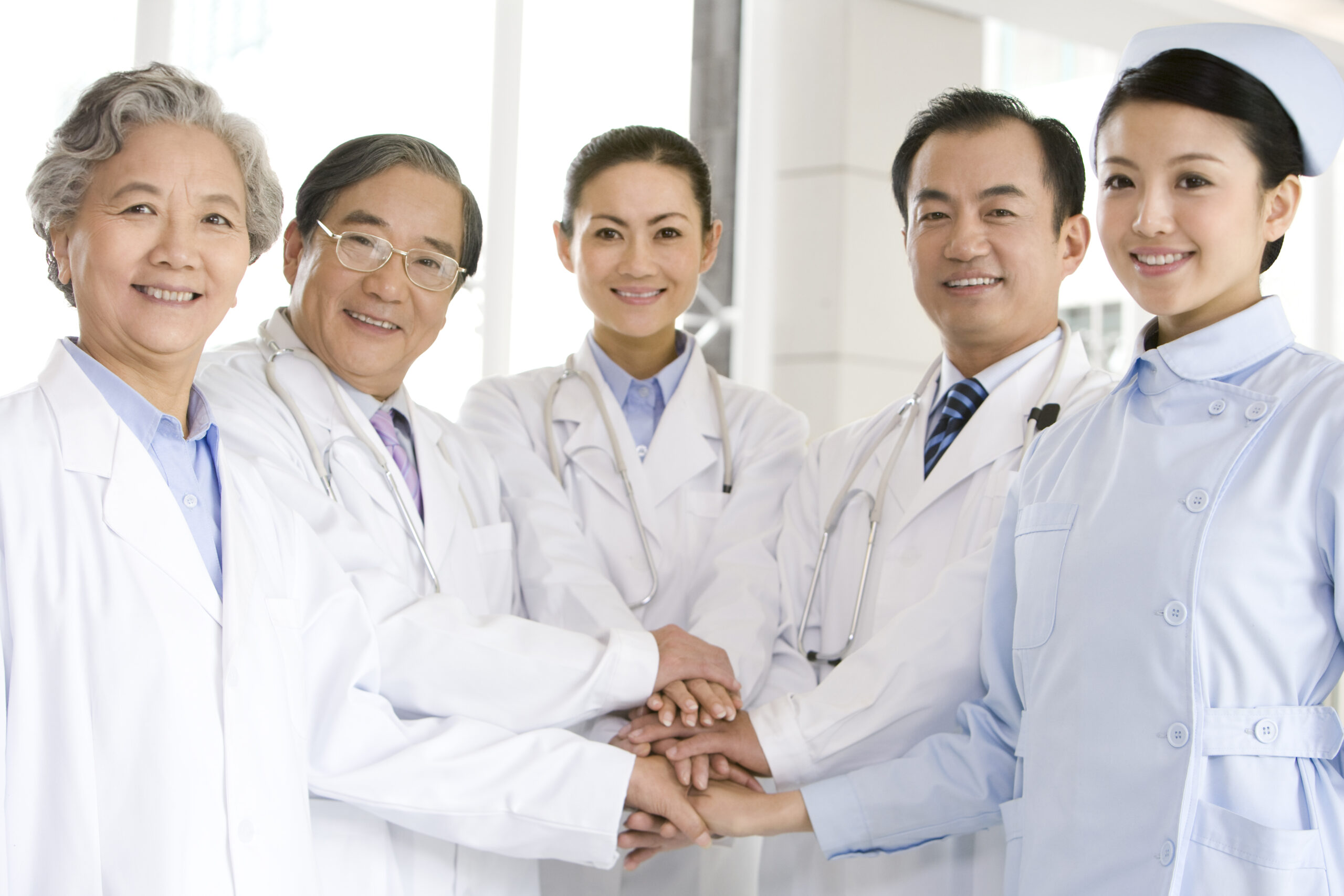 Diverse medical team showing unity with hands stacked