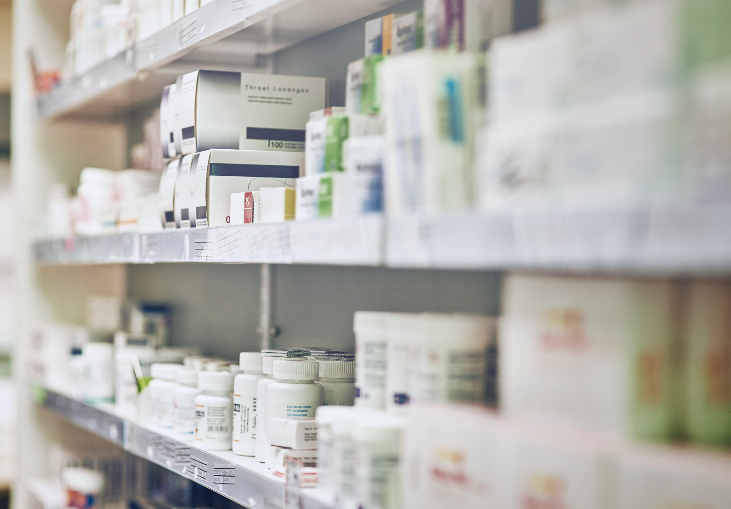 Pharmacy shelves stocked with various medications and boxes.