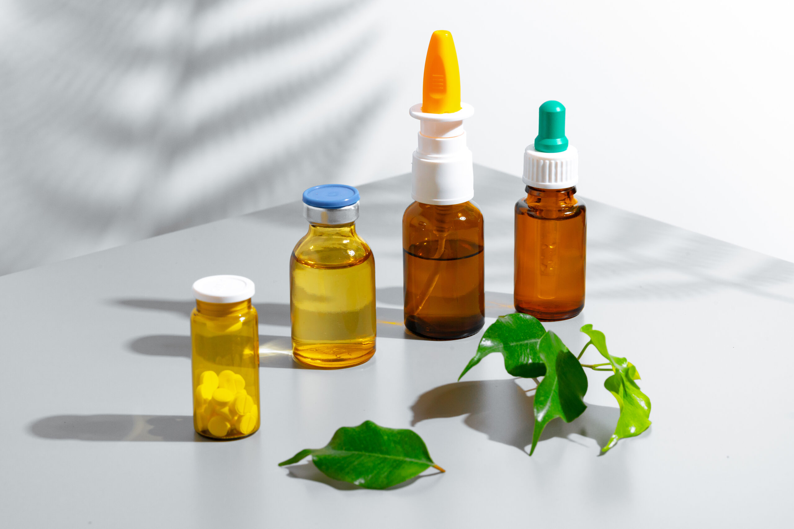 Assortment of amber bottles with medicine and pills, natural leaves