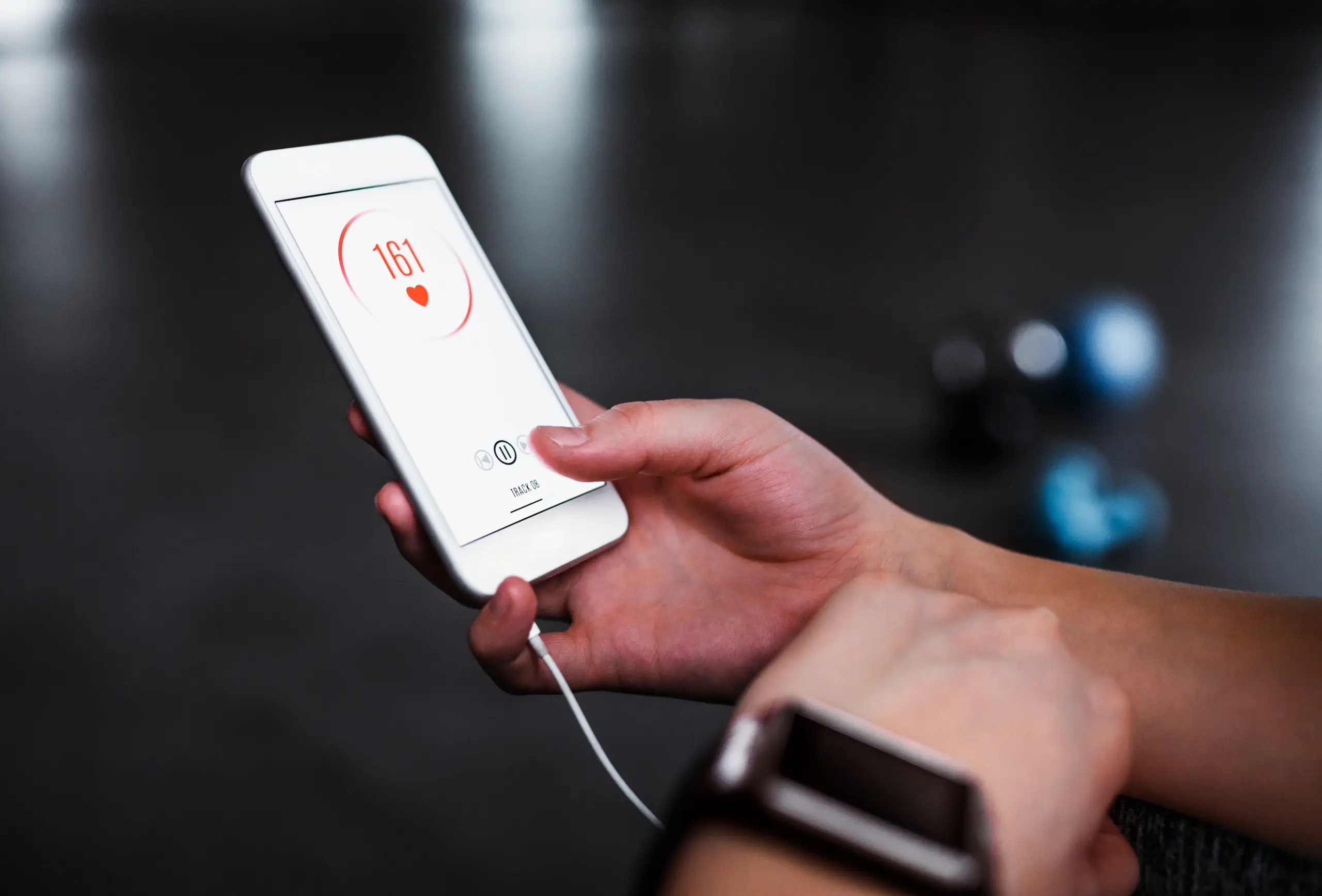 Person checking heart rate, 161 bpm, on fitness app.