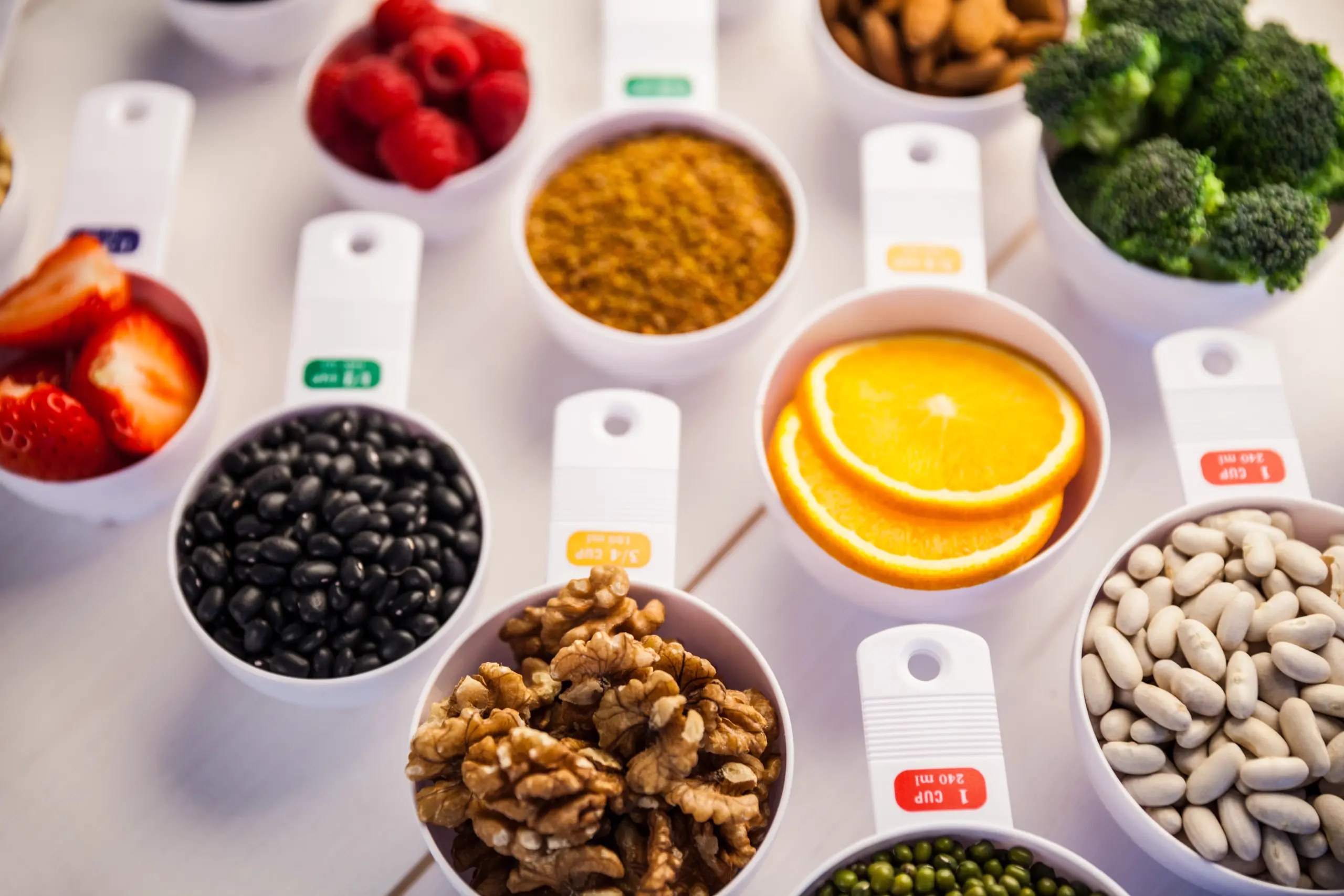 Various healthy foods measured in cups: strawberries, raspberries, beans, nuts, and more.