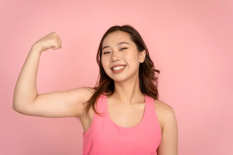 Woman flexing her arm showing muscle, Cystatin C is not affected by muscle mass