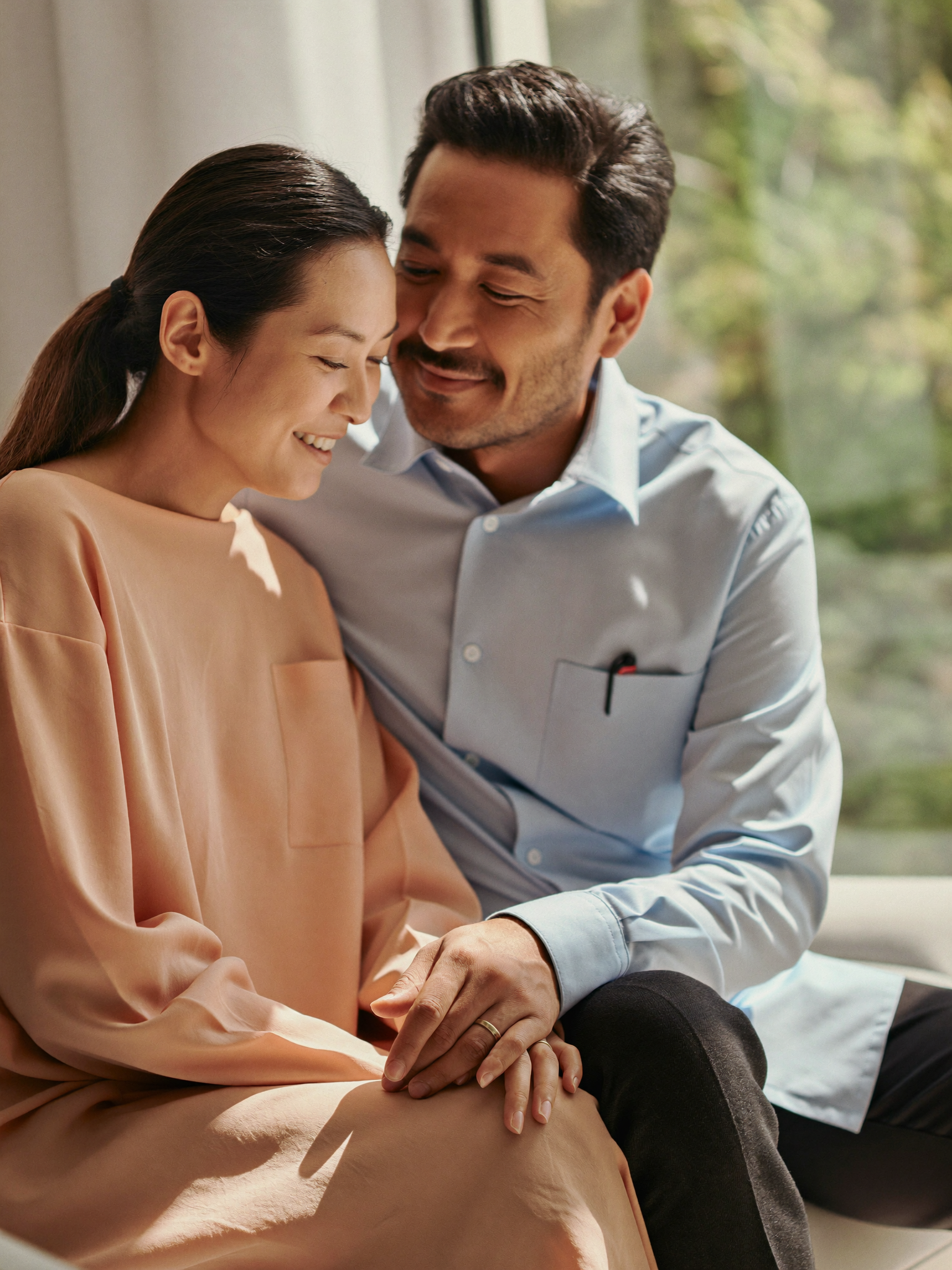 Malaysian couple planning for a baby, sharing a warm moment at home